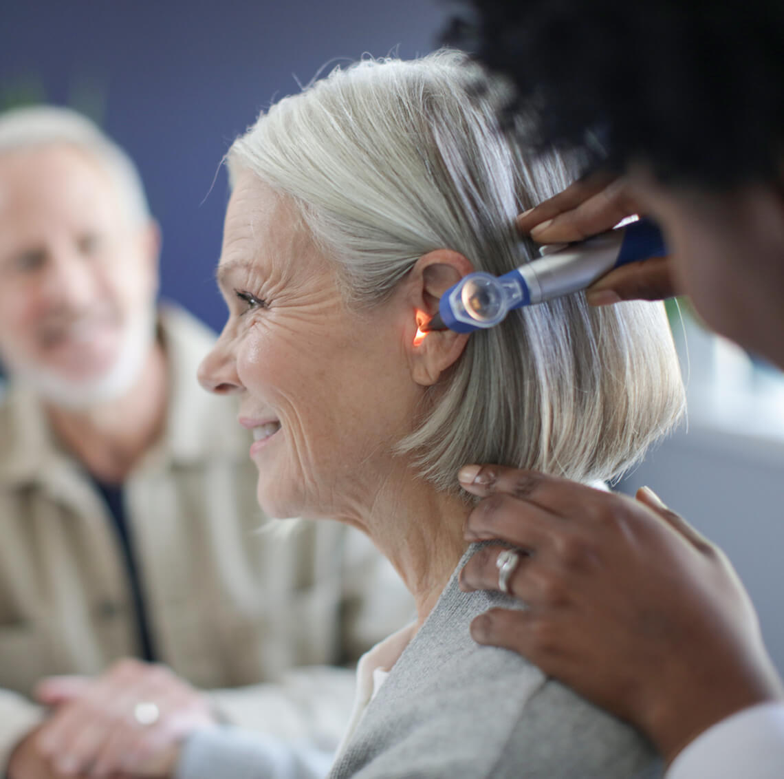 Audiologist looking into a patients ear.