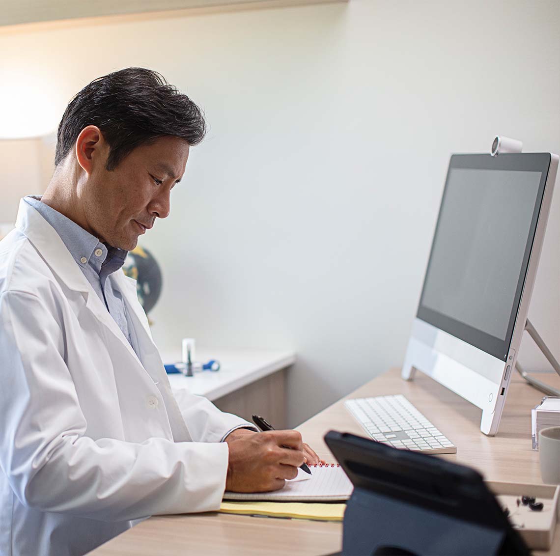 Hearing professional at computer taking notes