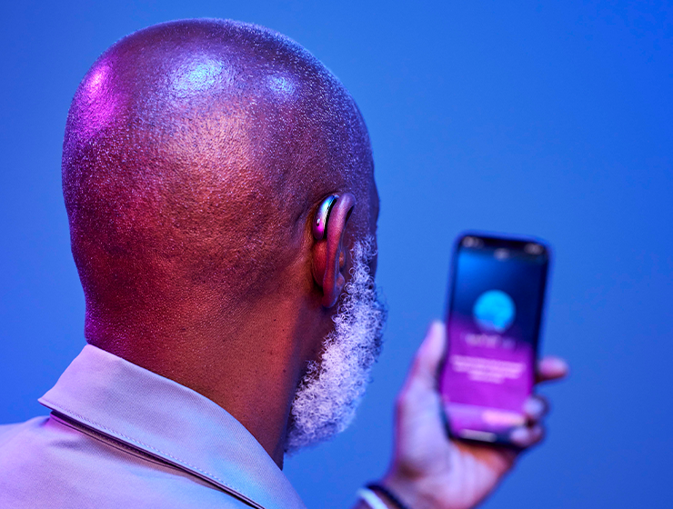 Man holding phone with My Starkey app.
