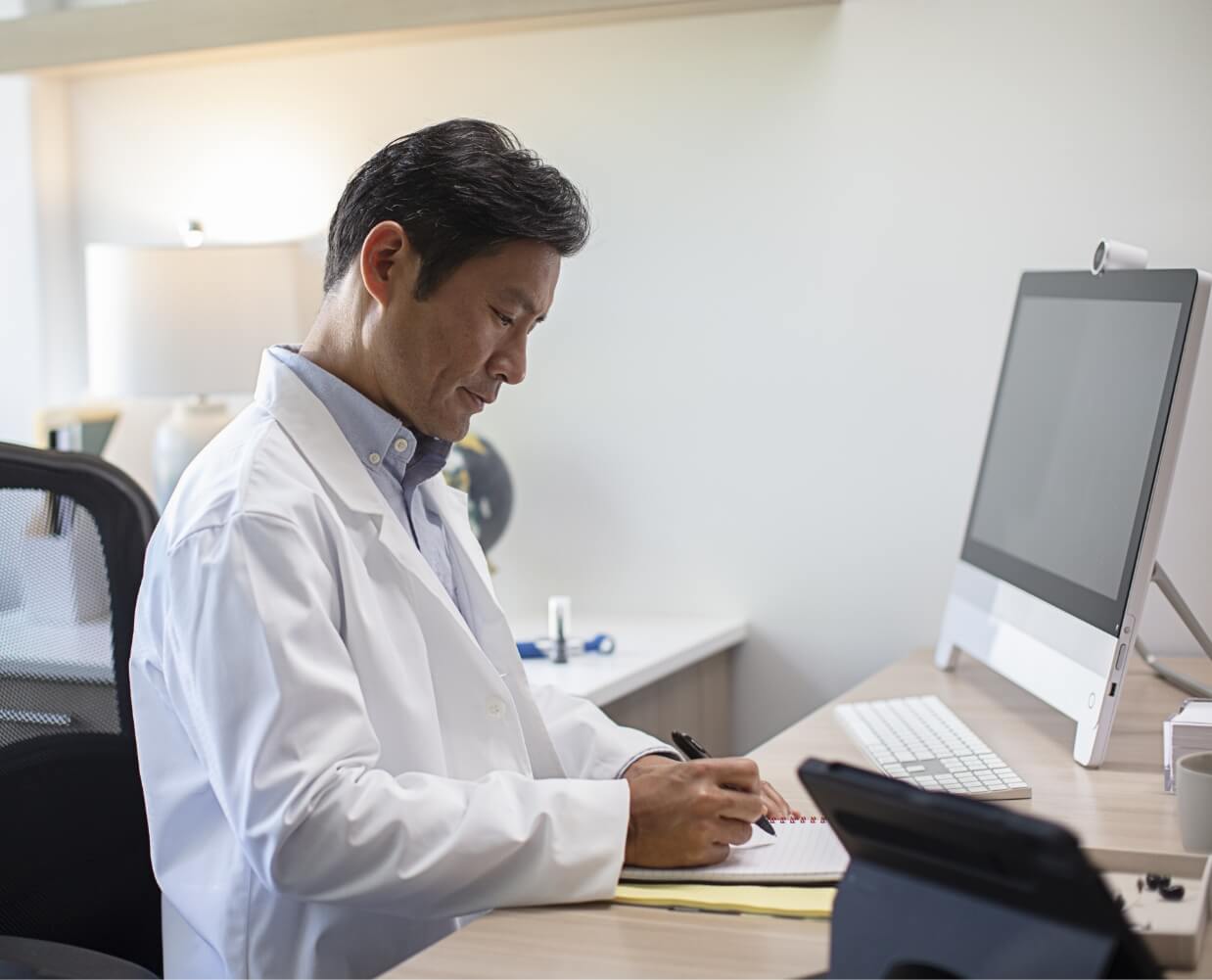 Hearing professional taking notes by a computer